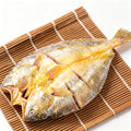 Whole yellow croaker split and scored on a bamboo mat