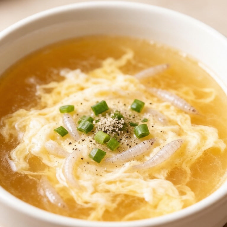 Whitebait in a golden egg drop soup topped with spring onion