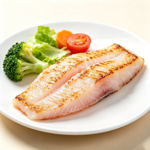 Pan-seared basa fillet on a white plate with broccoli and tomato